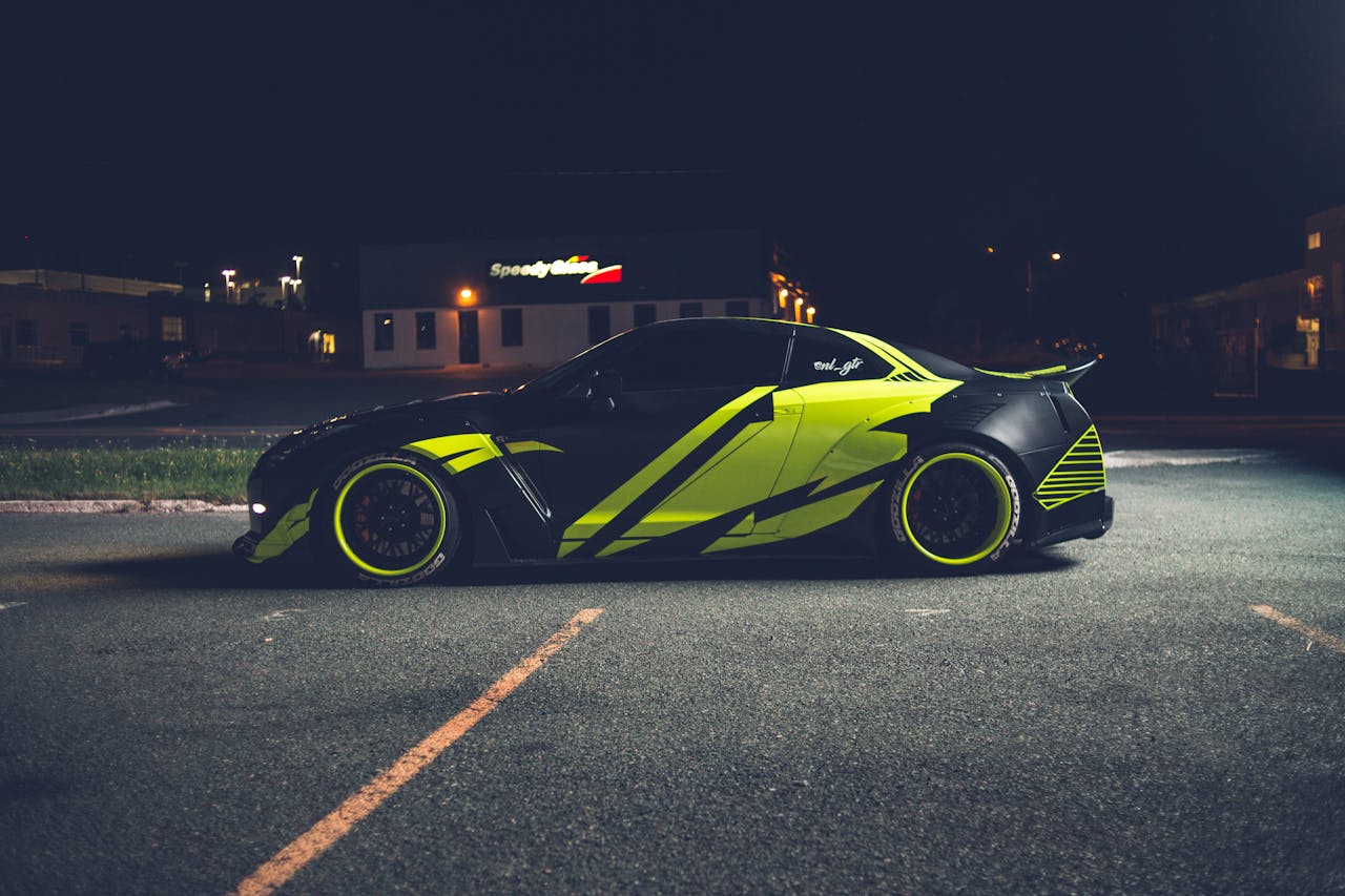 A sleek black and yellow car parked in an urban area at night, showcasing modern design and style.